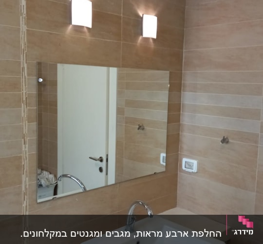 מראה מלבנית גדולה מעל כיור בחדר אמבטיה